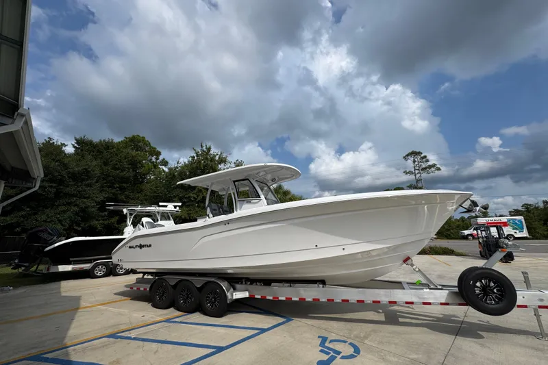 Slide: The Image of 2026 NauticStar 332 Offshore boat on trailer under cloudy sky. - 8