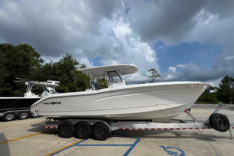 Slide: The Image of 2026 NauticStar 332 Offshore boat on trailer under cloudy sky. - 9