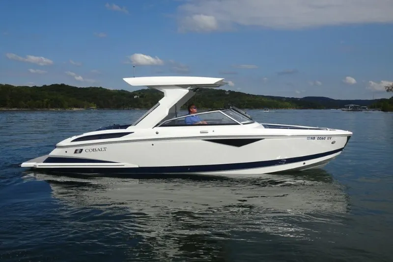 Slide: The Image of 2023 Cobalt A29 boat cruising on a serene lake under a clear sky. - 1