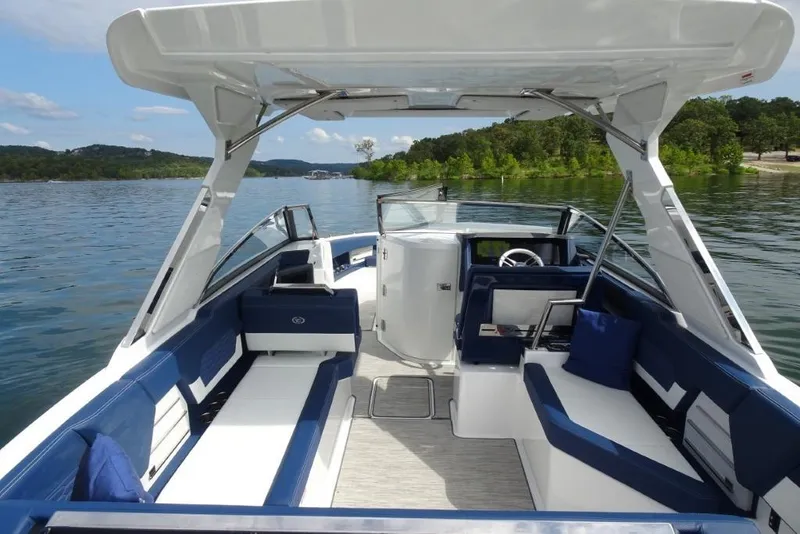 Slide: The Image of 2023 Cobalt A29 boat interior with blue and white seating on a scenic lake. - 11