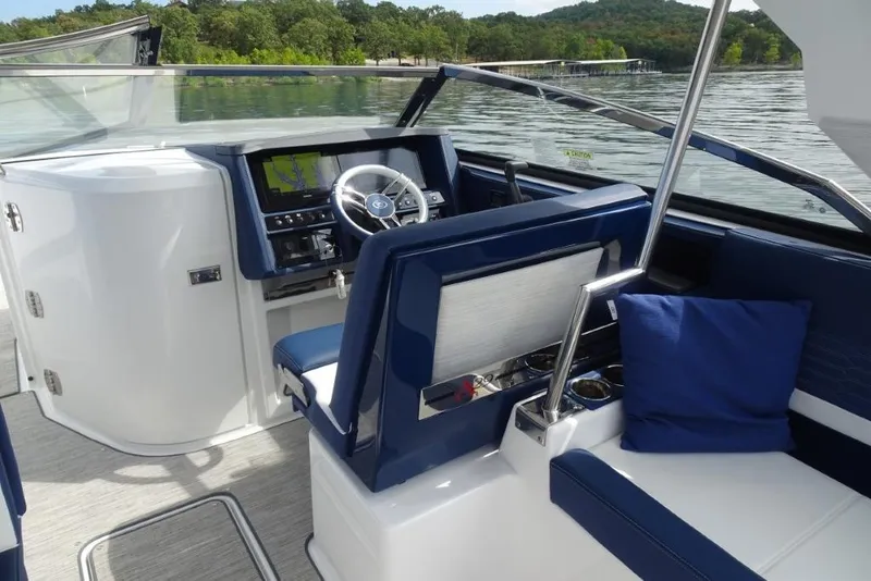 Slide: The Image of 2023 Cobalt A29 boat interior with blue seating, steering wheel, and navigation display. - 15