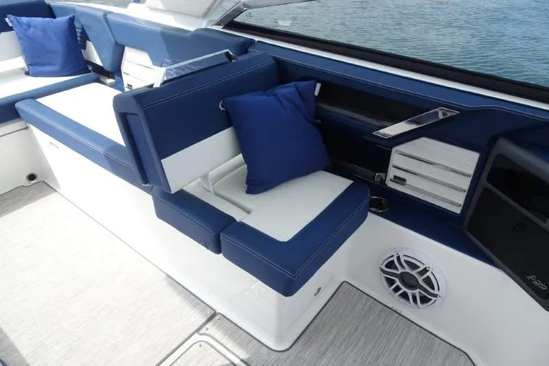 Slide: The Image of 2023 Cobalt A29 boat interior with blue and white seating, cushions, and speaker. - 22
