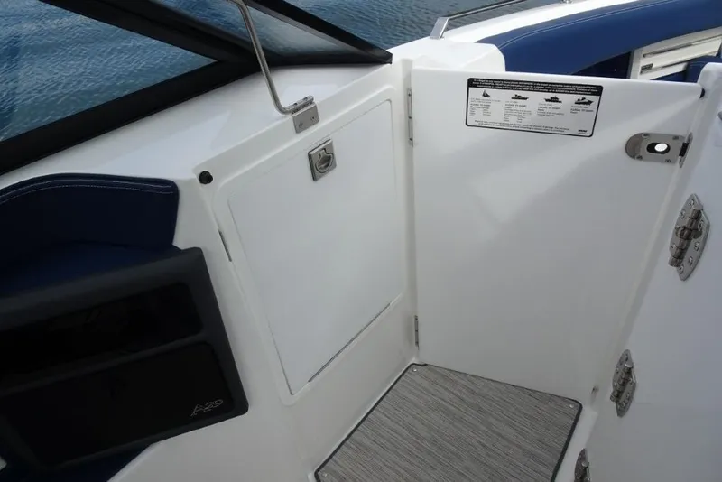 Slide: The Image of 2023 Cobalt A29 boat interior, featuring sleek white and blue design with storage compartment. - 24