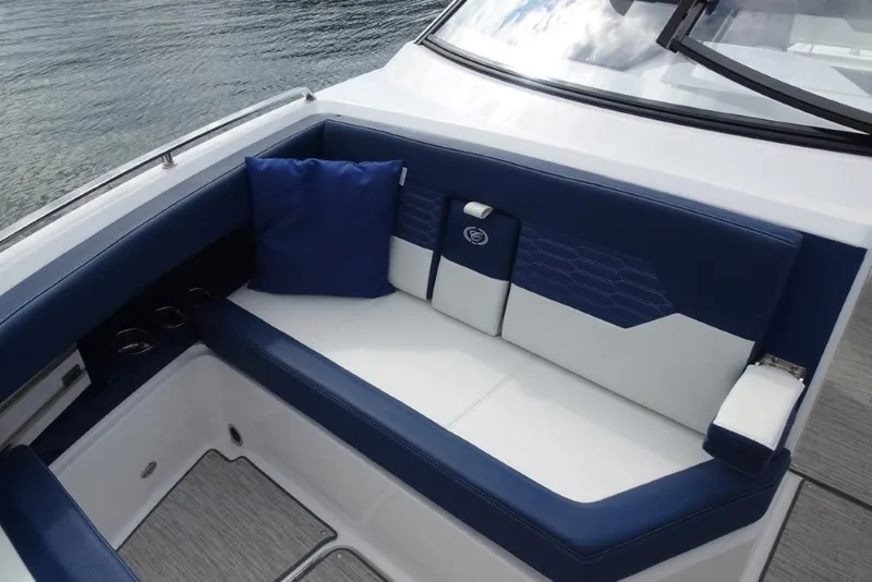 Slide: The Image of 2023 Cobalt A29 boat interior with blue and white seating, cushion, and cup holders. - 28
