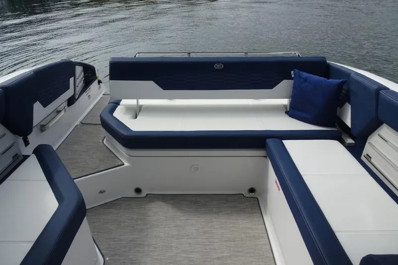 Slide: The Image of 2023 Cobalt A29 boat interior with blue and white seating, on calm water. - 29