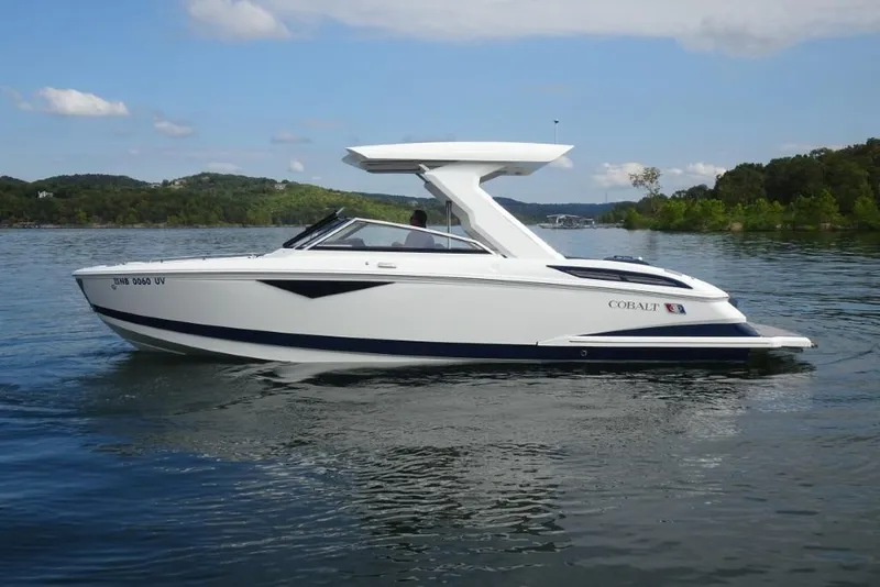 Slide: The Image of 2023 Cobalt A29 boat cruising on a serene lake with scenic background. - 5