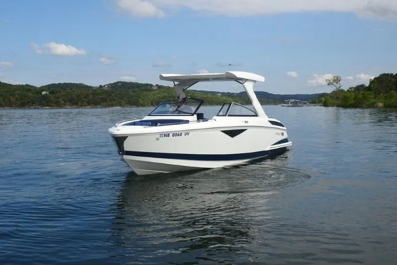 Slide: The Image of 2023 Cobalt A29 boat cruising on a serene lake with scenic hills in the background. - 6