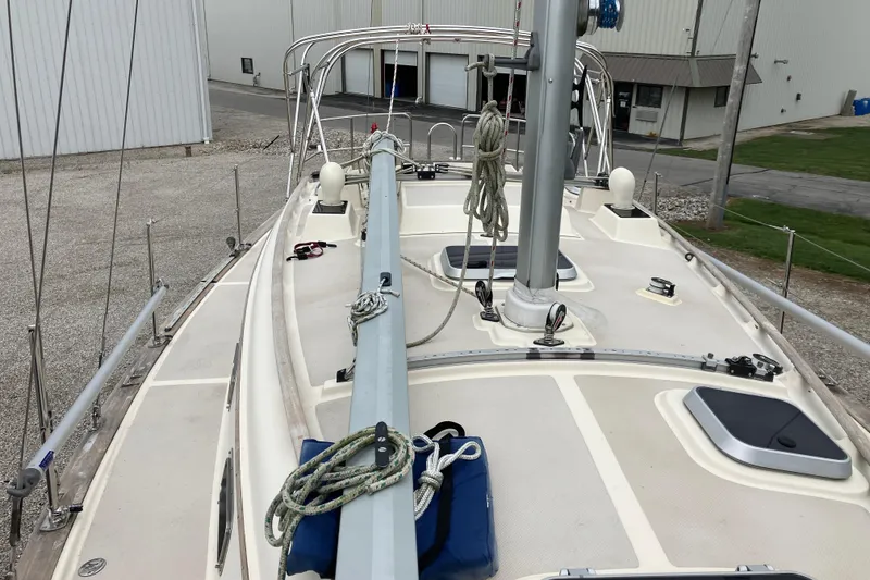 Slide: The Image of 1990 Island Packet 32 Cutter sailboat deck with rigging and hatches in a marina setting. - 11