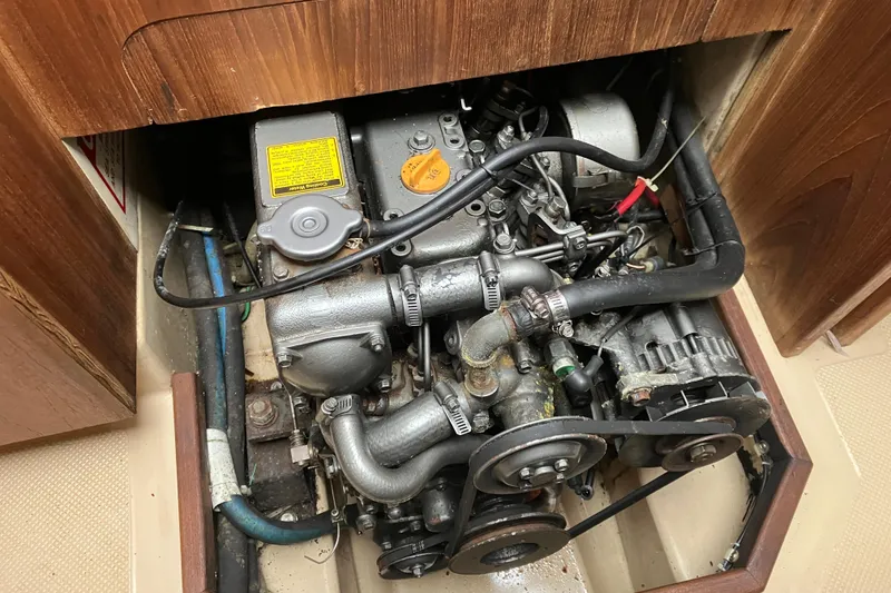 Slide: The Image of Engine compartment of a 1990 Island Packet 32 Cutter sailboat, showing detailed mechanical components. - 24