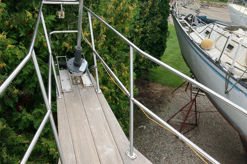 Slide: The Image of Deck view of a 1990 Island Packet 32 Cutter sailboat, featuring stainless steel railings. - 13