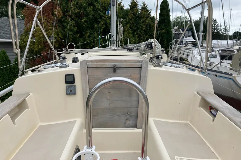 Slide: The Image of 1990 Island Packet 32 Cutter sailboat cockpit with wooden hatch and stainless steel railing. - 47