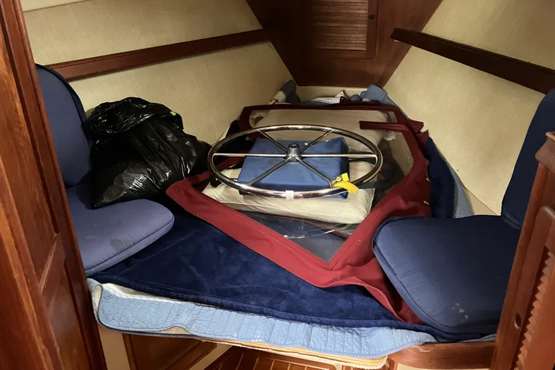 Slide: The Image of Interior of 1990 Island Packet 32 Cutter with blue cushions and stored steering wheel. - 29