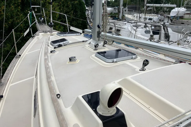 Slide: The Image of 1990 Island Packet 32 Cutter sailboat deck with hatches and rigging, docked in a marina. - 16