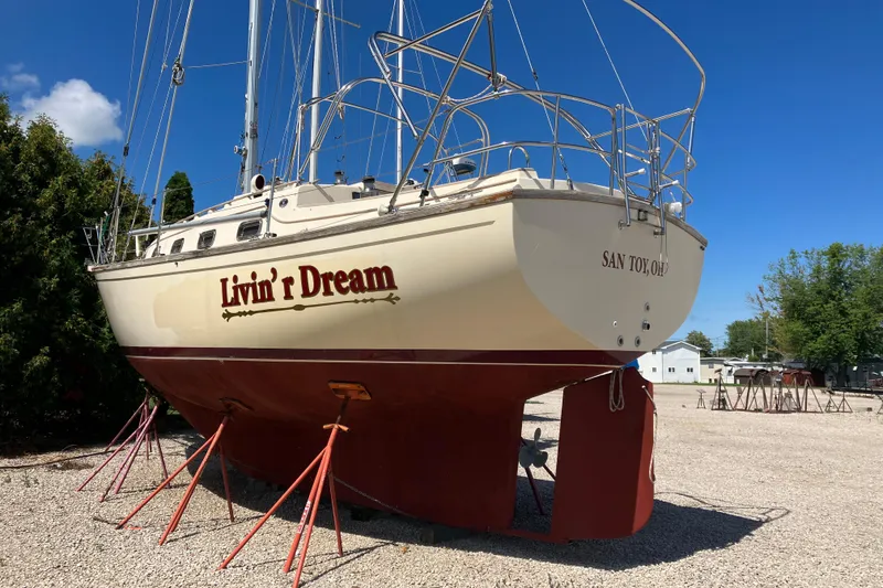 Slide: The Image of 1990 Island Packet 32 sailboat "Livin' r Dream" on stands, clear blue sky background. - 3