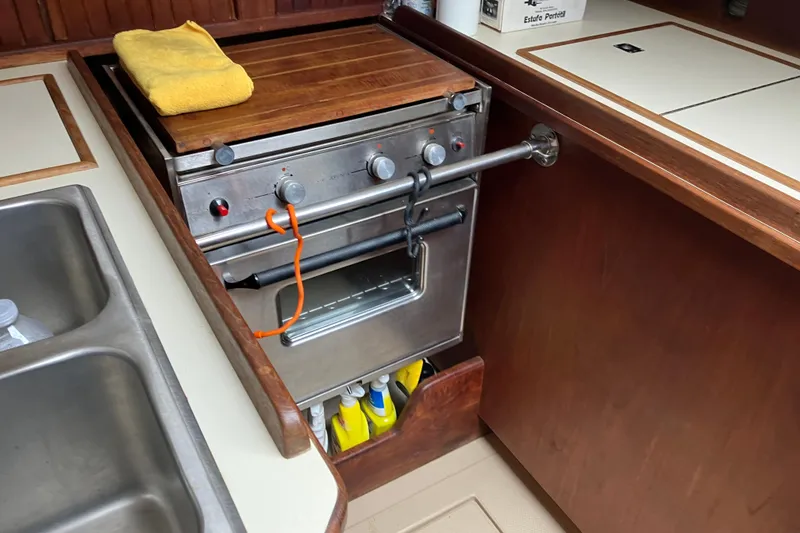 Slide: The Image of 1990 Island Packet 32 yacht kitchen with stove, sink, and storage. - 30
