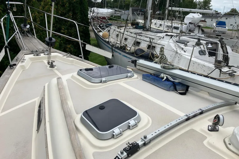 Slide: The Image of 1990 Island Packet 32 Cutter sailboat deck with hatches and rigging in marina setting. - 15