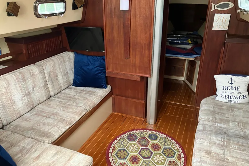 Slide: The Image of Interior of 1990 Island Packet 32 Cutter with cozy seating and nautical decor. - 20