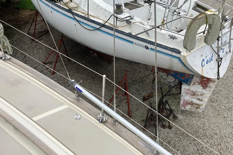 Slide: The Image of 1990 Island Packet 32 Cutter sailboat on dry dock, alongside another boat. - 9