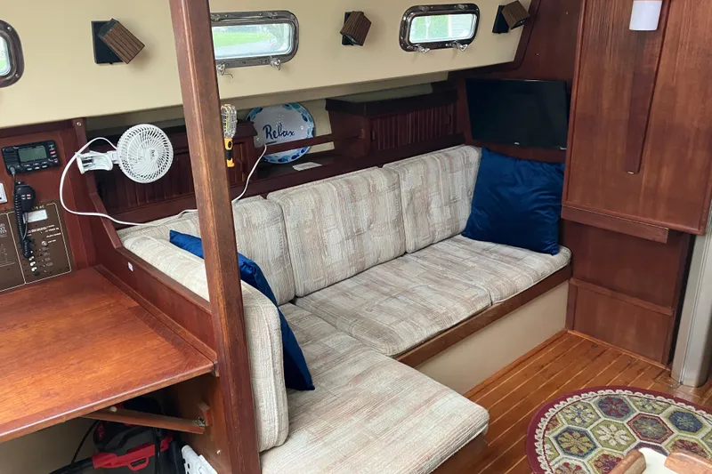 Slide: The Image of Interior of 1990 Island Packet 32 Cutter sailboat with cozy seating and wooden accents. - 21