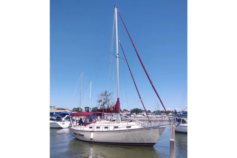 Slide: The Image of 1990 Island Packet 32 sailboat docked in a marina under clear blue skies. - 48