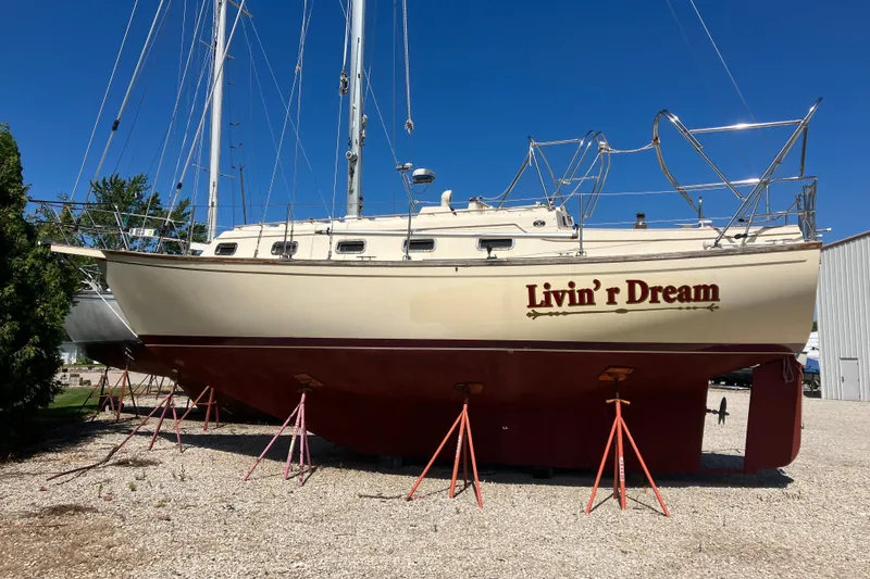 Slide: The Image of 1990 Island Packet 32 sailboat "Livin' r Dream" on stands, clear blue sky background. - 2