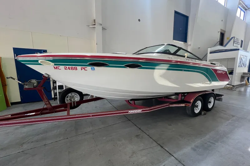 The Image of 1990 Powerplay Powerboats Spectra XL on trailer, vibrant design, parked outdoors. - 0