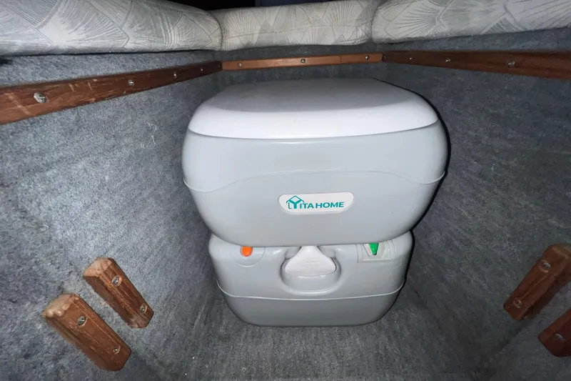 Slide: The Image of Interior cabin of 1990 Powerplay Spectra XL boat with cushions and portable toilet. - 15
