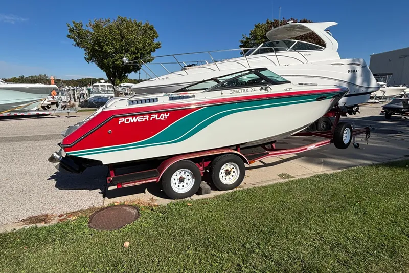 Slide: The Image of 1990 Powerplay Powerboats Spectra XL on trailer, vibrant red and teal design, parked outdoors. - 18