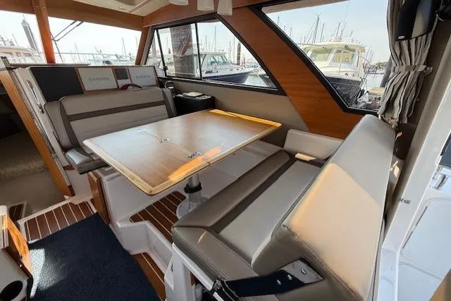 Slide: The Image of 2024 Cutwater C-30 Sedan interior with dining area, featuring cushioned seating and wooden table. - 12