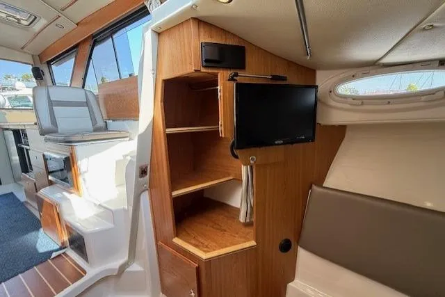 Slide: The Image of 2024 Cutwater C-30 Sedan interior with wooden cabinetry and mounted TV. - 17