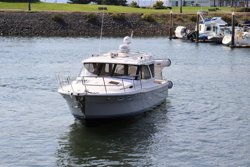 Slide: The Image of 2024 Cutwater C-30 Sedan boat cruising on a calm waterway near a marina. - 3