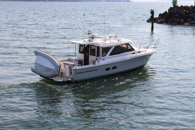 Slide: The Image of 2024 Cutwater C-30 Sedan cruising on calm waters near rocky shoreline. - 4