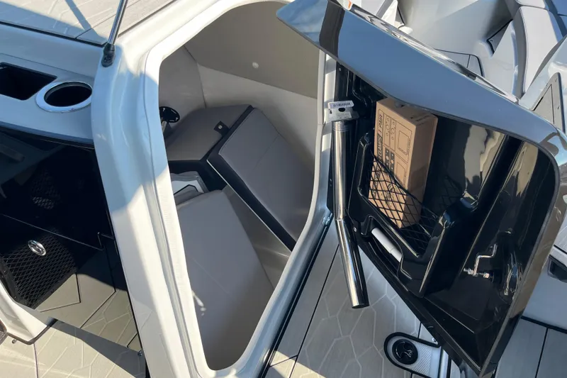 Slide: The Image of 2024 Yamaha Boats 255XD interior storage compartment with seating and cup holder. - 20