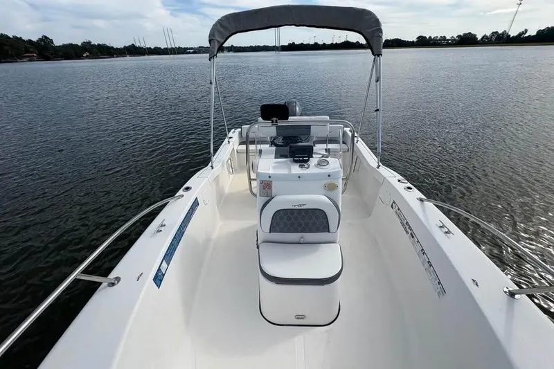 Slide: The Image of 2017 Tidewater 180 CC Adventure boat on calm water, featuring a spacious deck and canopy. - 10