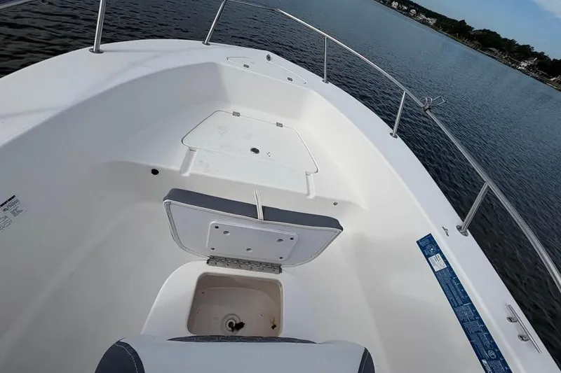 Slide: The Image of 2017 Tidewater 180 CC Adventure boat interior with open storage compartment on calm water. - 5