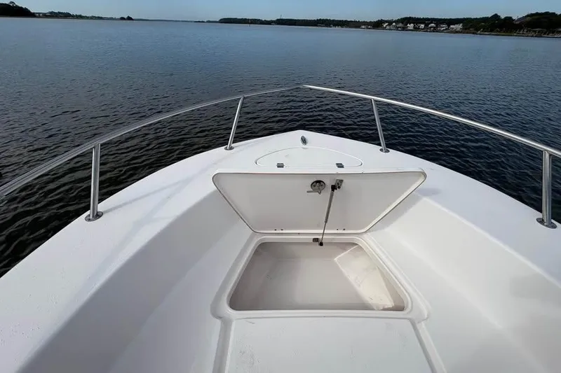 Slide: The Image of 2017 Tidewater 180 CC Adventure boat with open storage compartment on calm water. - 7