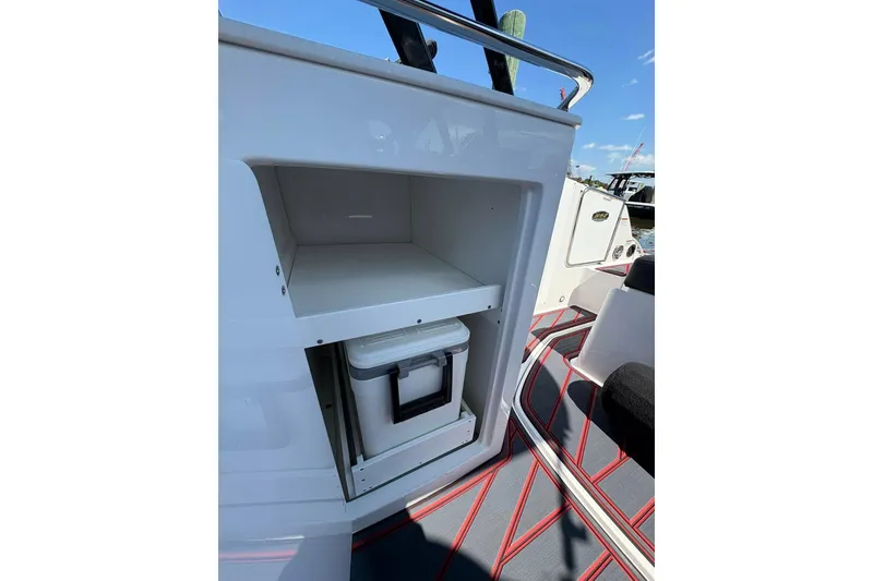 Slide: The Image of 2026 Monterey M65 boat interior with storage compartment and cooler, featuring sleek design. - 13