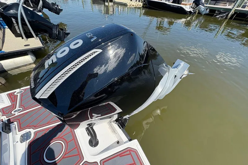 Slide: The Image of Outboard motor on a 2026 Monterey M65 boat docked by the water. - 21