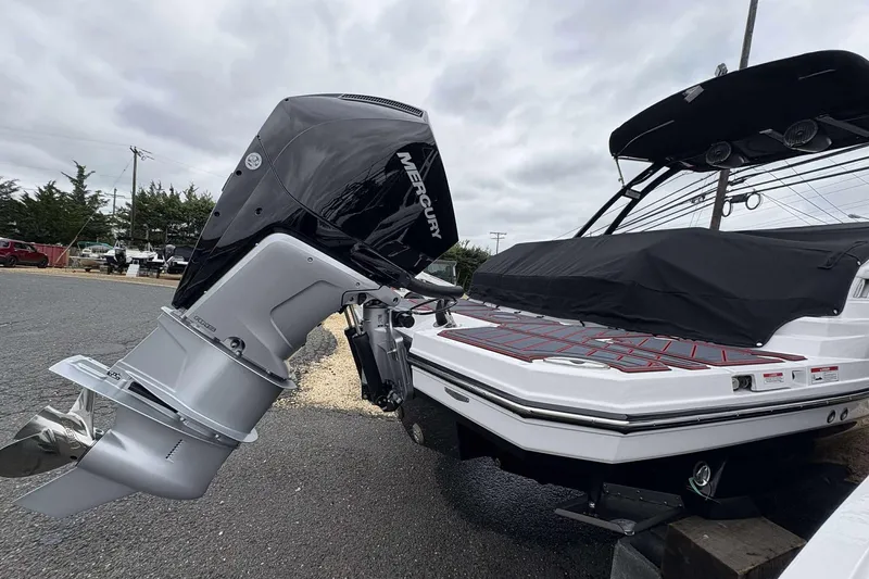 Slide: The Image of Monterey M65 2026 boat with Mercury outboard engine, covered deck, parked outdoors. - 8