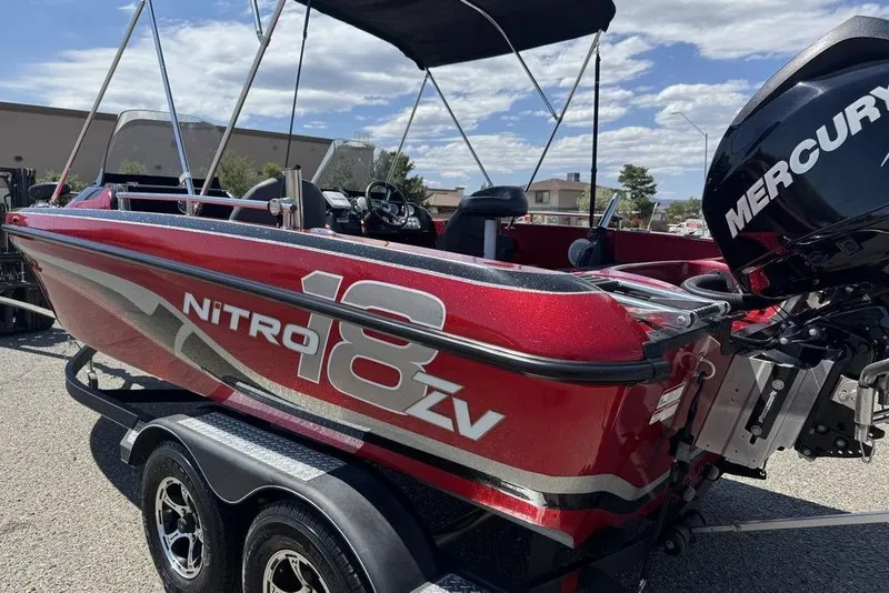 Slide: The Image of Red 2017 Nitro ZV18 boat with Mercury engine on trailer, under clear sky. - 10