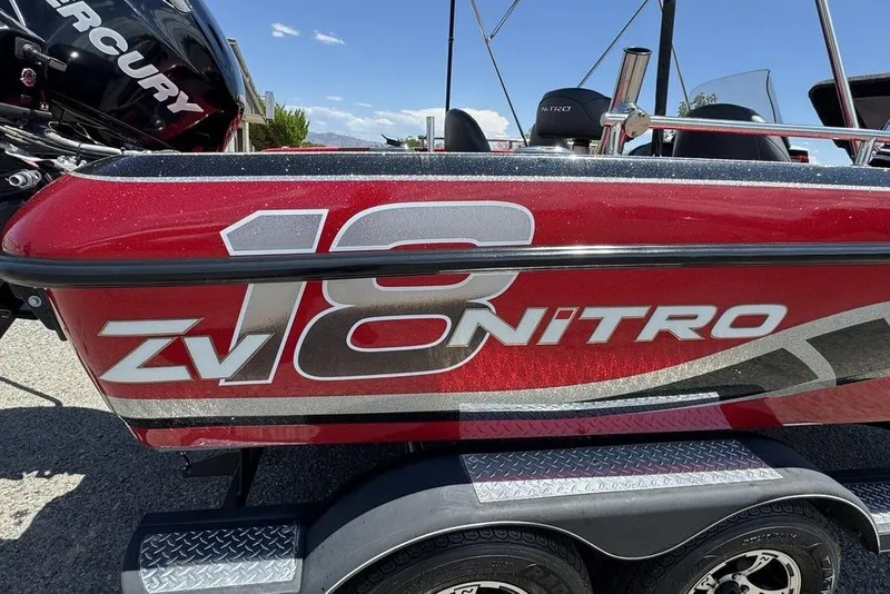 Slide: The Image of Red 2017 Nitro ZV18 boat with bold graphics, parked on a trailer. - 41
