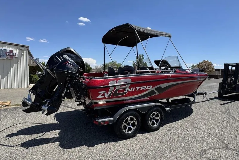 Slide: The Image of 2017 Nitro ZV18 boat with outboard motor on a trailer, parked outdoors. - 44