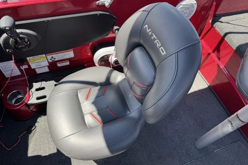 Slide: The Image of Gray leather seat in a 2017 Nitro ZV18 boat, featuring red accents and control panel. - 46
