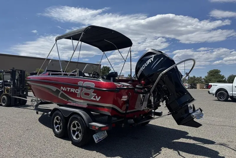 Slide: The Image of 2017 Nitro ZV18 boat with Mercury engine on trailer, parked outdoors under blue sky. - 6