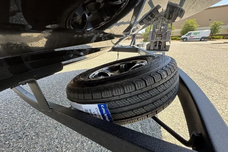Slide: The Image of Spare tire mounted on a 2017 Nitro ZV18 trailer, parked on asphalt. - 72