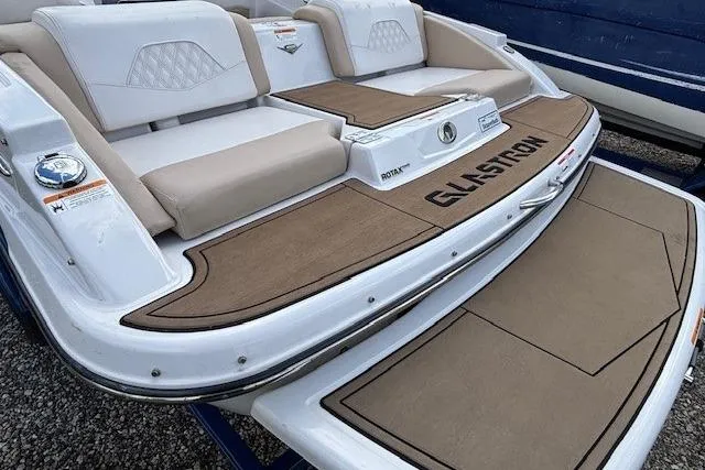 Slide: The Image of 2018 Glastron GT 187 boat with cushioned seating and teak-style deck. - 12