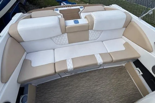Slide: The Image of 2018 Glastron GT 187 boat interior with beige and white cushioned seating. - 13