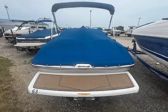 Slide: The Image of 2018 Glastron GT 187 boat with blue cover, parked in a marina. - 27