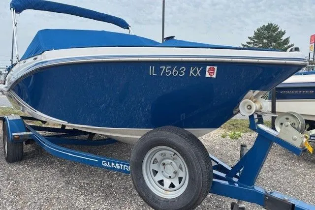 Slide: The Image of 2018 Glastron GT 187 boat on trailer, blue cover, parked outdoors. - 29