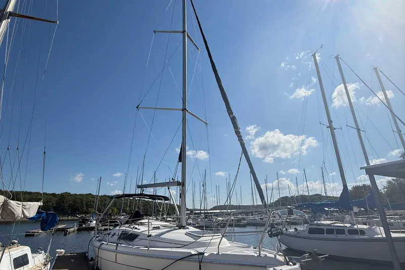 Slide: The Image of Sailboats docked at a marina under a clear blue sky, featuring a 2007 Hunter 31. - 16